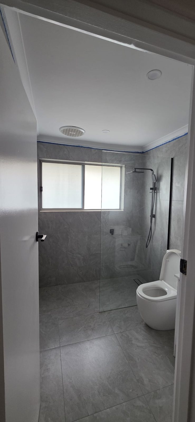 Fully renovated bathroom with a frameless glass shower and floor-to-ceiling tiles in Thomastown